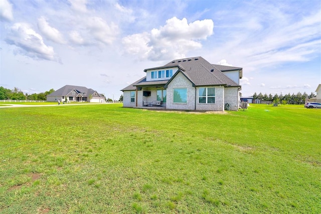 rear view of house featuring a lawn