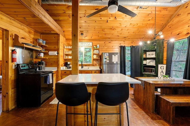 kitchen featuring lofted ceiling with beams, stainless steel fridge, wood ceiling, and black range with electric cooktop