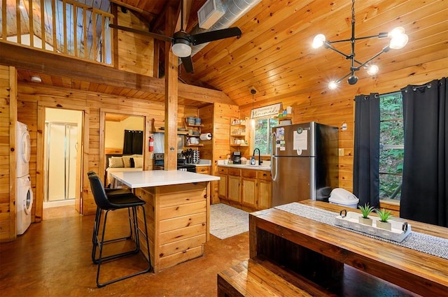 kitchen featuring stainless steel refrigerator, wood walls, a center island, and wood ceiling