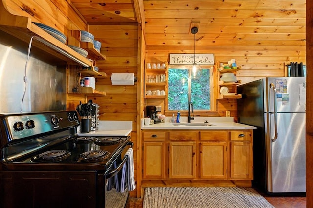 kitchen with sink, wooden walls, hanging light fixtures, black electric range, and stainless steel refrigerator