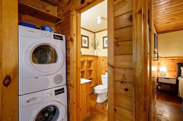 washroom with wooden walls and stacked washer / drying machine