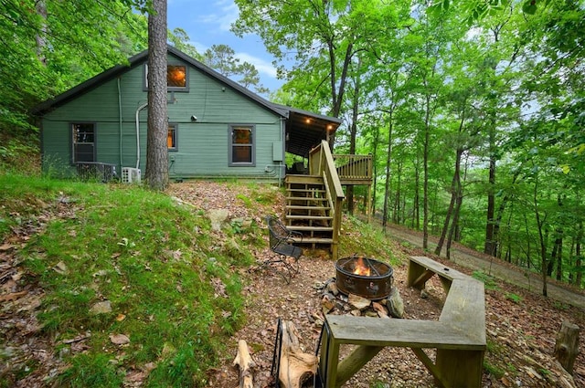 rear view of property with a deck and an outdoor fire pit