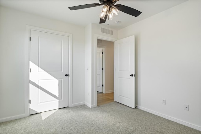 unfurnished bedroom featuring light colored carpet and ceiling fan