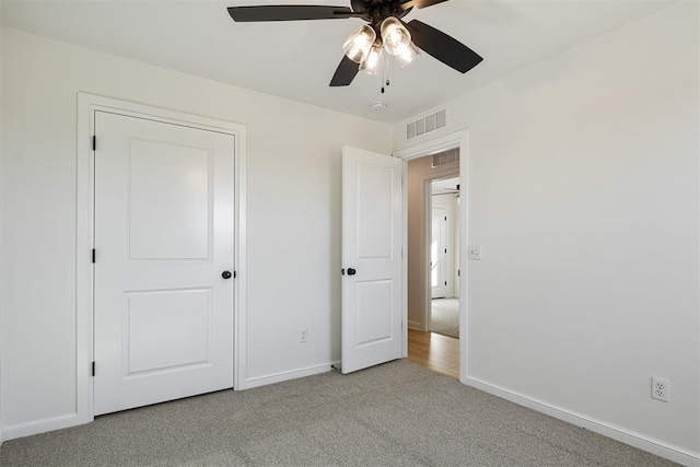 unfurnished bedroom with ceiling fan and light colored carpet