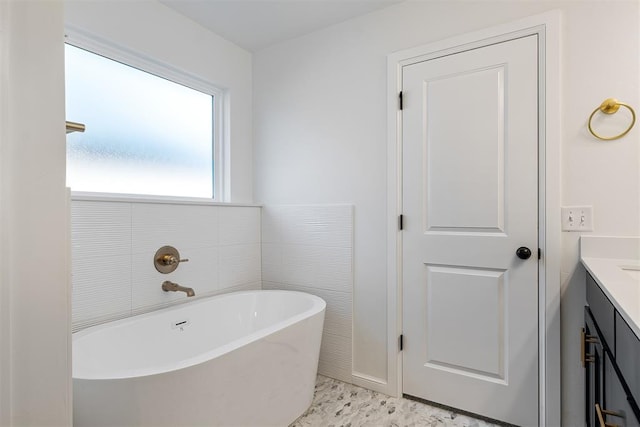 bathroom featuring a bath, vanity, and tile walls