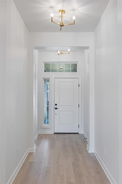 entryway featuring light wood-type flooring and an inviting chandelier