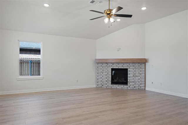 unfurnished living room featuring ceiling fan, light wood-type flooring, a fireplace, and vaulted ceiling