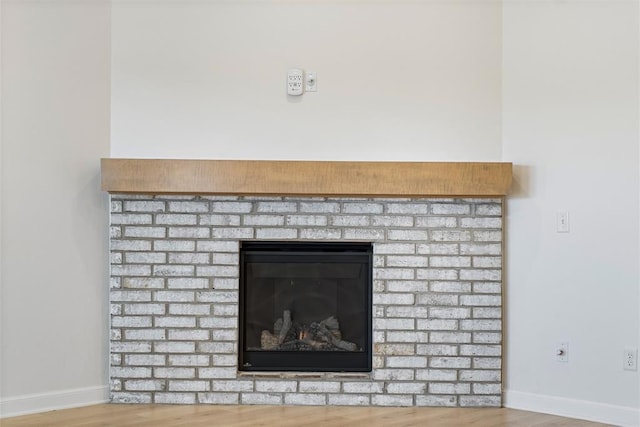 details featuring wood-type flooring and a brick fireplace