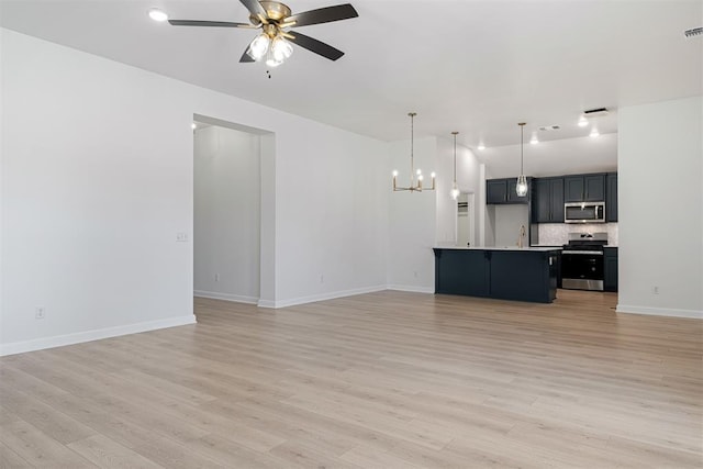 unfurnished living room featuring light hardwood / wood-style flooring and ceiling fan with notable chandelier