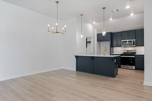 kitchen with light wood-type flooring, stainless steel appliances, sink, pendant lighting, and lofted ceiling