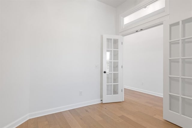 spare room featuring french doors and light hardwood / wood-style floors