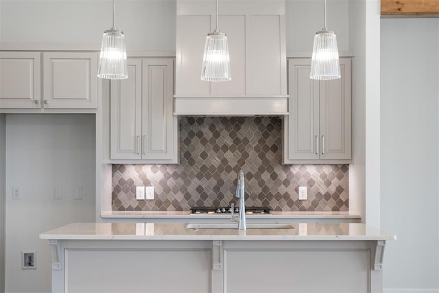 kitchen featuring backsplash, decorative light fixtures, and stainless steel gas stovetop