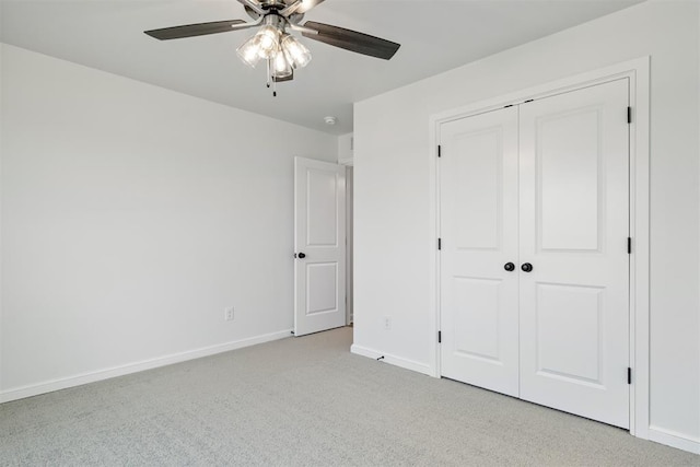 unfurnished bedroom with ceiling fan, light carpet, and a closet