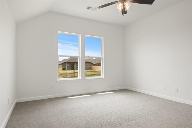 carpeted spare room with ceiling fan and vaulted ceiling