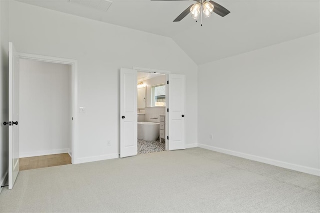 unfurnished bedroom featuring ceiling fan, light colored carpet, ensuite bathroom, and lofted ceiling