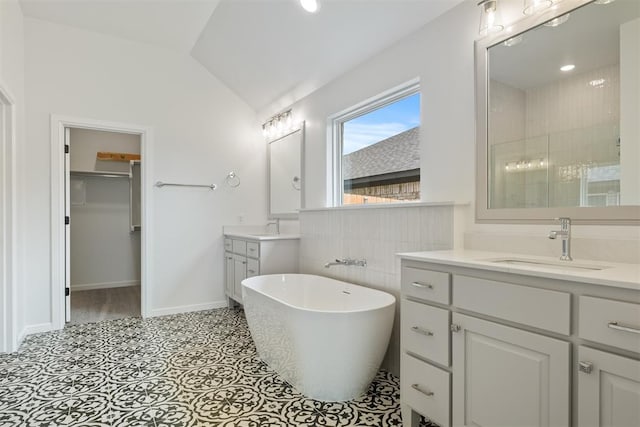 bathroom featuring tile patterned floors, vanity, separate shower and tub, and vaulted ceiling