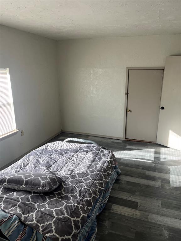 bedroom featuring dark hardwood / wood-style flooring and a textured ceiling