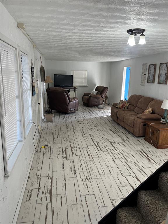 living room featuring a textured ceiling and light hardwood / wood-style flooring