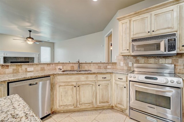 kitchen with sink, ceiling fan, decorative backsplash, light tile patterned floors, and stainless steel appliances