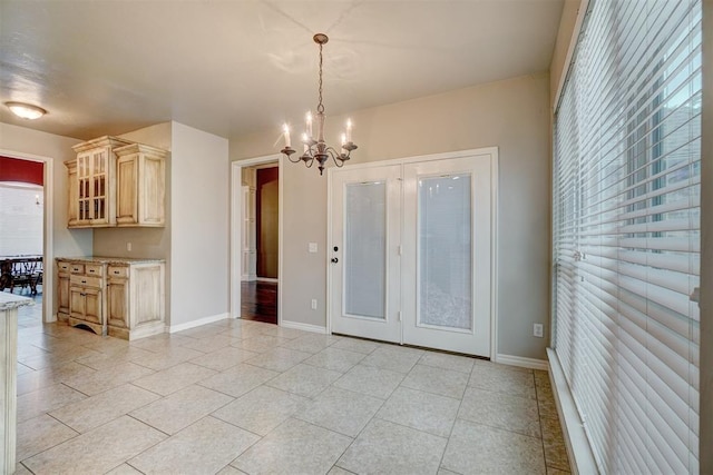 kitchen featuring light brown cabinetry, hanging light fixtures, a healthy amount of sunlight, and an inviting chandelier