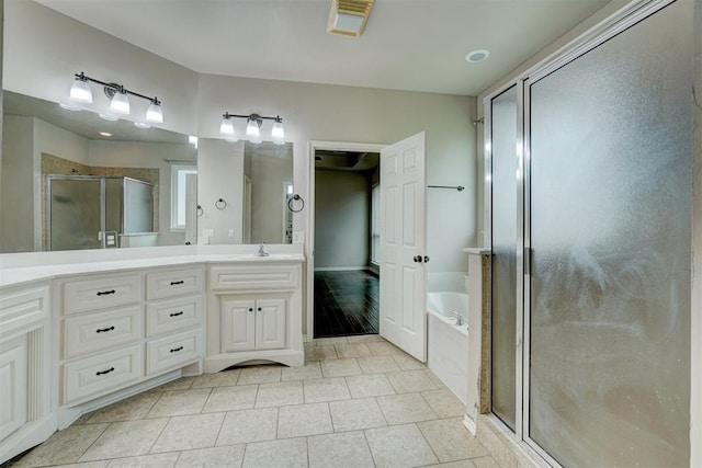 bathroom featuring tile patterned flooring, vanity, and shower with separate bathtub