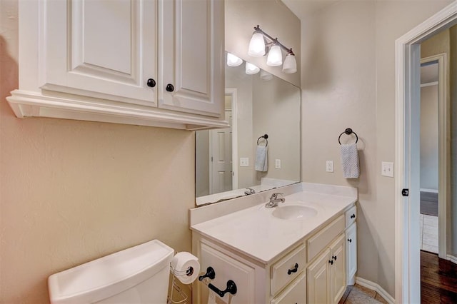 bathroom with vanity, toilet, and wood-type flooring