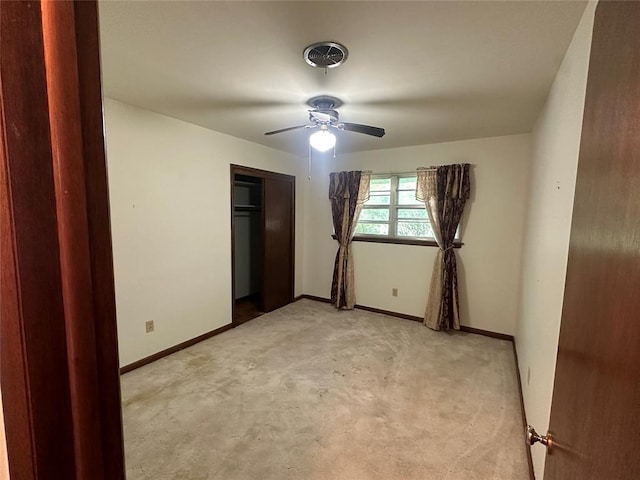 unfurnished bedroom with light carpet, a closet, and ceiling fan