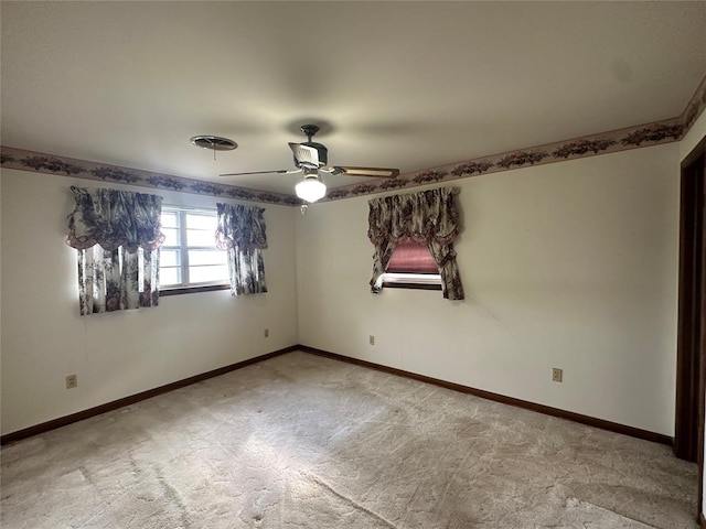 unfurnished room with light colored carpet and ceiling fan