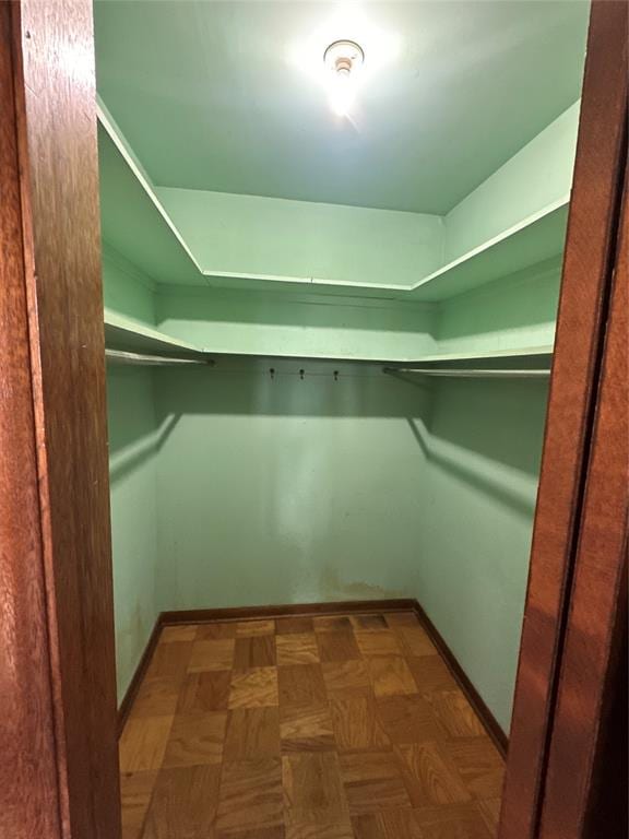 spacious closet featuring dark parquet floors