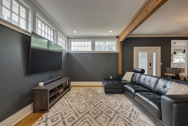 living room with beamed ceiling, light hardwood / wood-style floors, ornamental molding, and sink