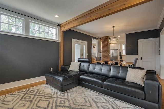 living room featuring beam ceiling, hardwood / wood-style flooring, an inviting chandelier, and crown molding