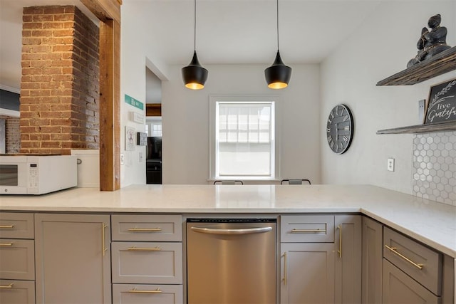 kitchen with pendant lighting, stainless steel dishwasher, decorative backsplash, gray cabinets, and light stone countertops