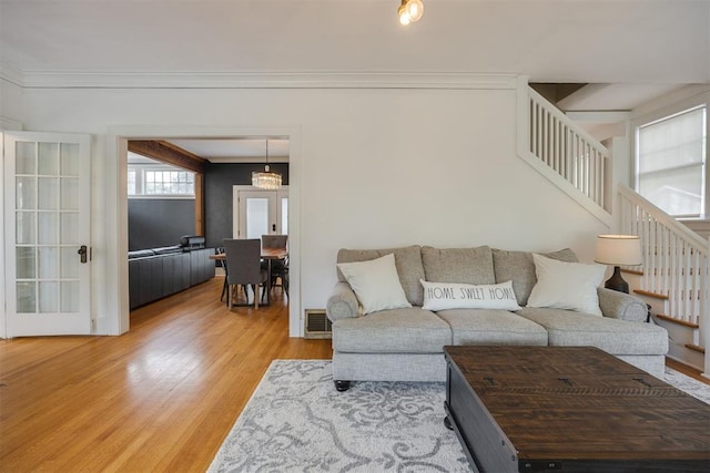 living room with wood-type flooring and crown molding