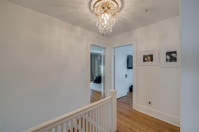 hall featuring a notable chandelier and light wood-type flooring