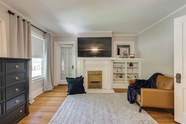 sitting room featuring a fireplace, light hardwood / wood-style floors, and ornamental molding