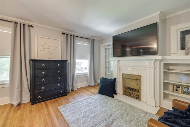 sitting room featuring a fireplace, crown molding, plenty of natural light, and light wood-type flooring