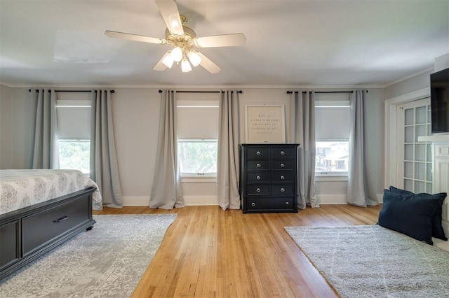 bedroom with ceiling fan, light wood-type flooring, and ornamental molding