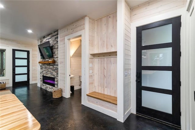 interior space featuring wood walls and a fireplace