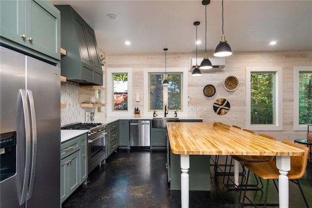 kitchen with stainless steel appliances, a breakfast bar, decorative light fixtures, wood walls, and sink