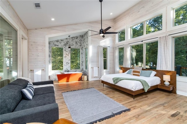 bedroom with light hardwood / wood-style floors and a towering ceiling