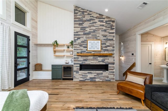 living room featuring wooden walls, light hardwood / wood-style floors, and wine cooler