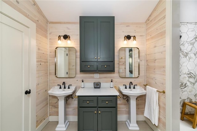 bathroom with dual sinks and wood walls