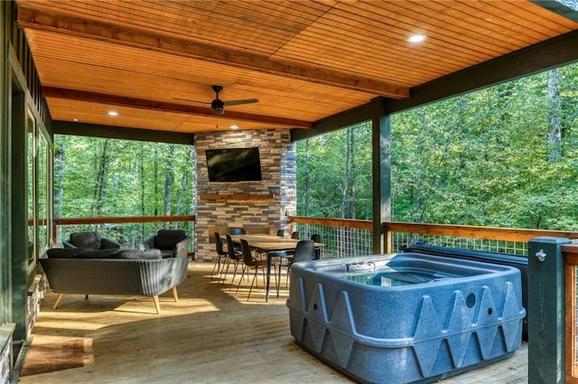 sunroom / solarium with ceiling fan, beamed ceiling, and wood ceiling