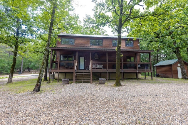 log-style house featuring a shed