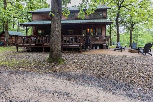 rear view of house featuring a patio area, a deck, and an outdoor fire pit