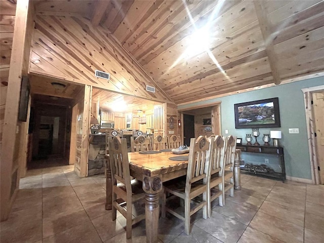 tiled dining room featuring vaulted ceiling and wood ceiling