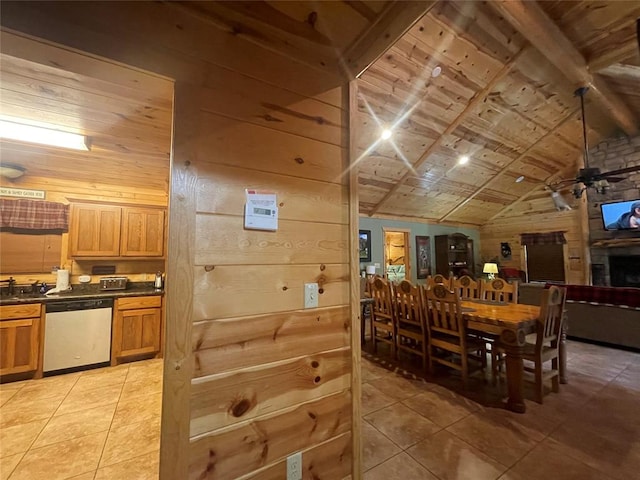 tiled dining room featuring wooden walls, ceiling fan, and lofted ceiling