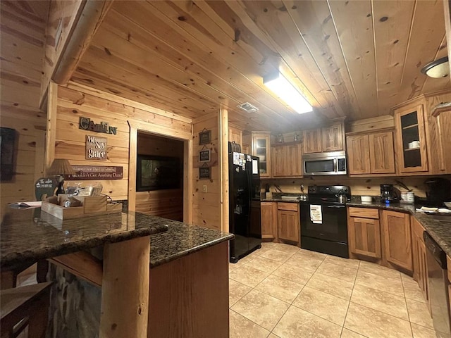 kitchen with wood walls, wooden ceiling, black appliances, dark stone countertops, and light tile patterned floors