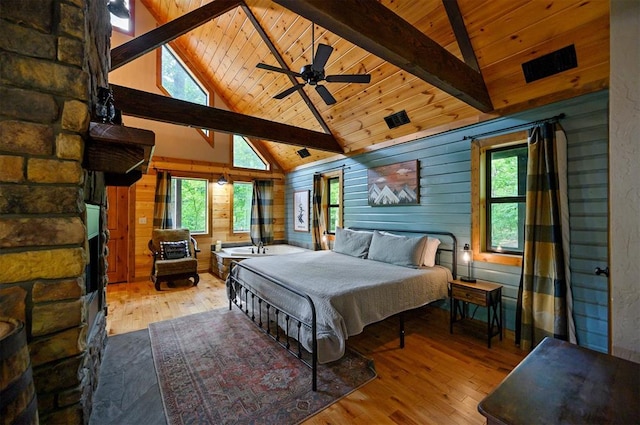 bedroom with high vaulted ceiling, light hardwood / wood-style flooring, and multiple windows