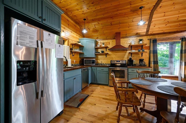 kitchen featuring decorative light fixtures, wood walls, stainless steel appliances, and range hood